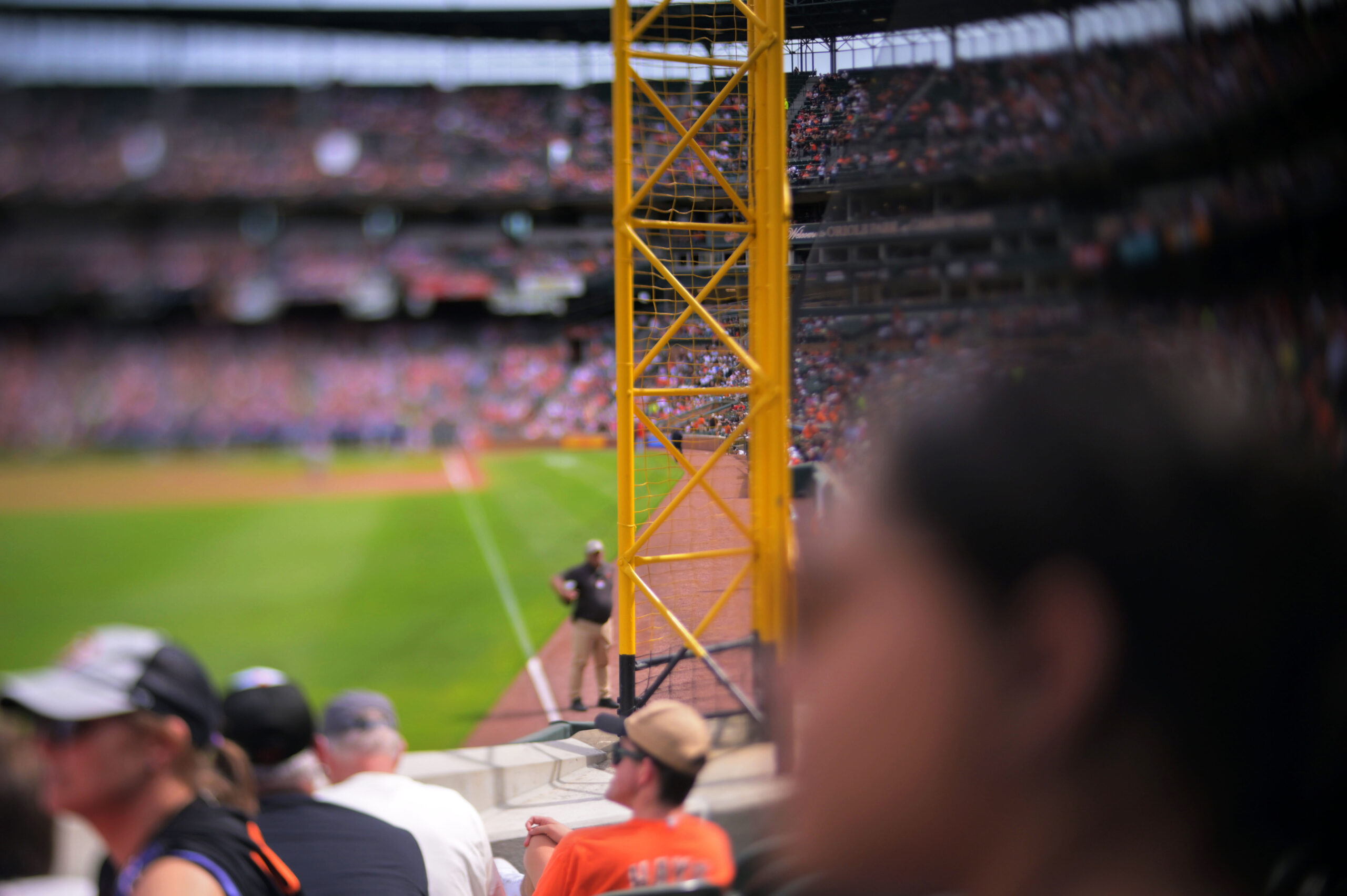 The left field foul pole rises above fans watching an...