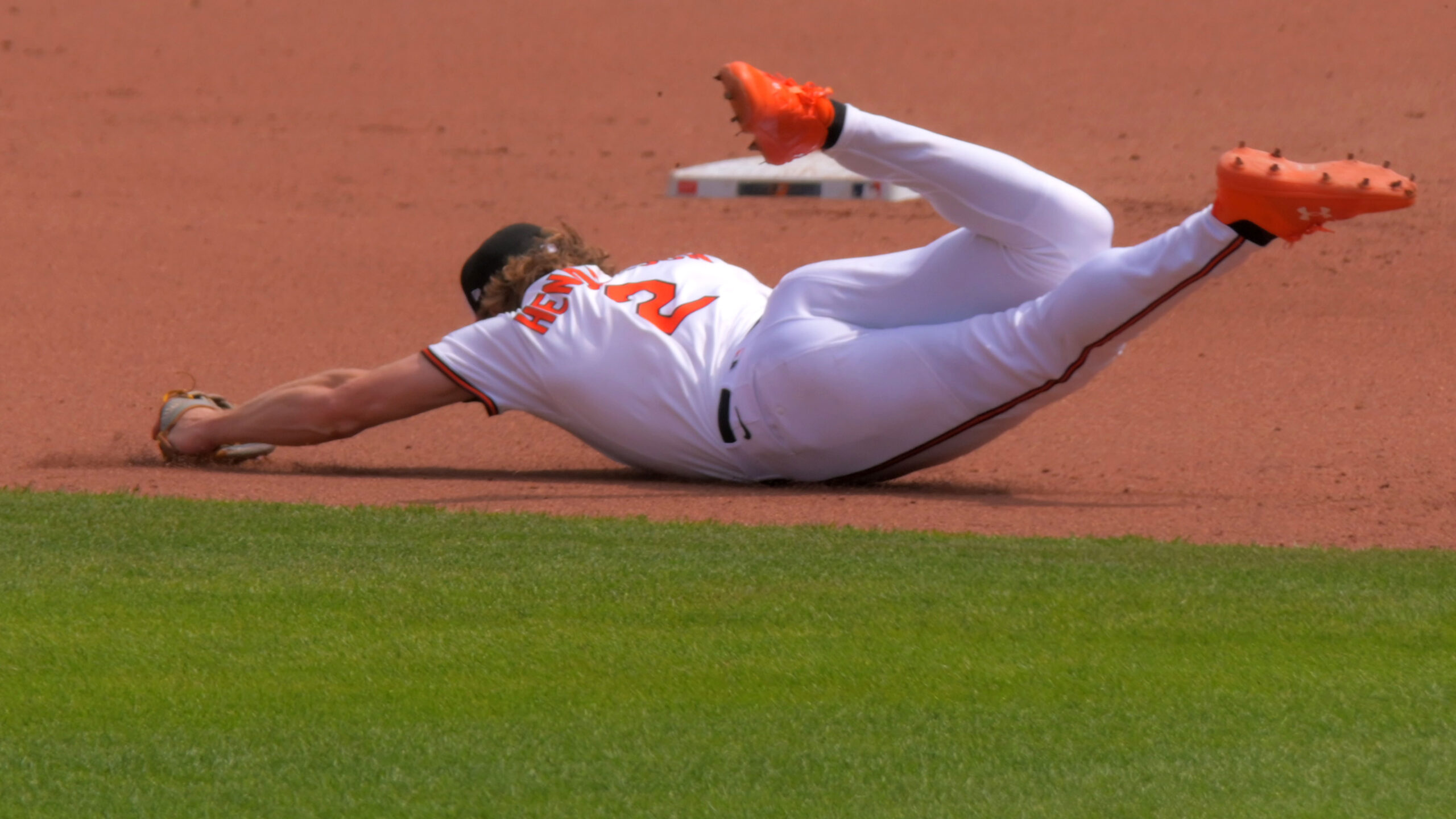 Orioles shortstop Gunnar Henderson hits the infield dirt after failing to stop a grounder from Reds catcher Austin Wynns. The Reds beat the Orioles, 24-2. (Karl Merton Ferron/Staff)