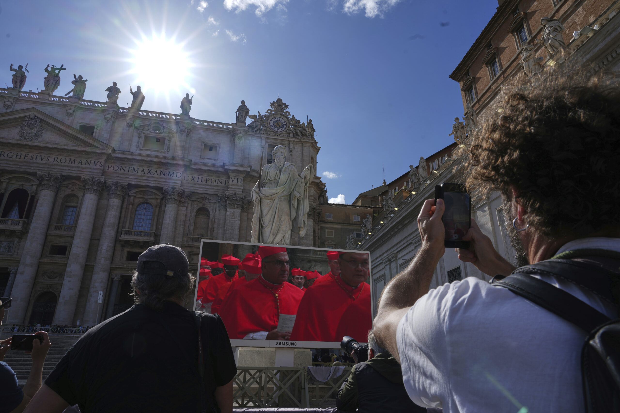Faithful watch a giant screen showing images of cardinals entering the conclave