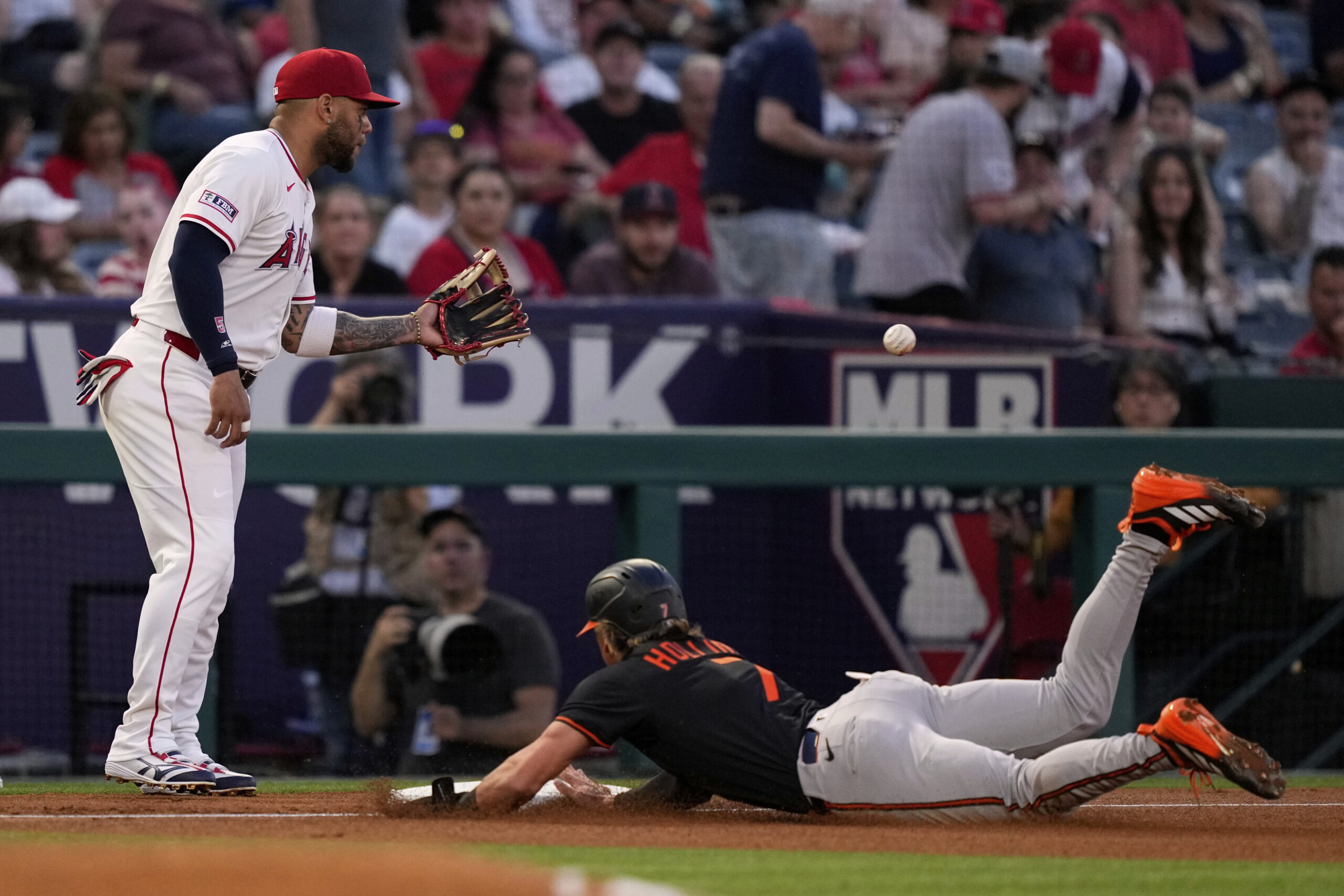 Baltimore Orioles' Jackson Holliday, right, dives into third on a...