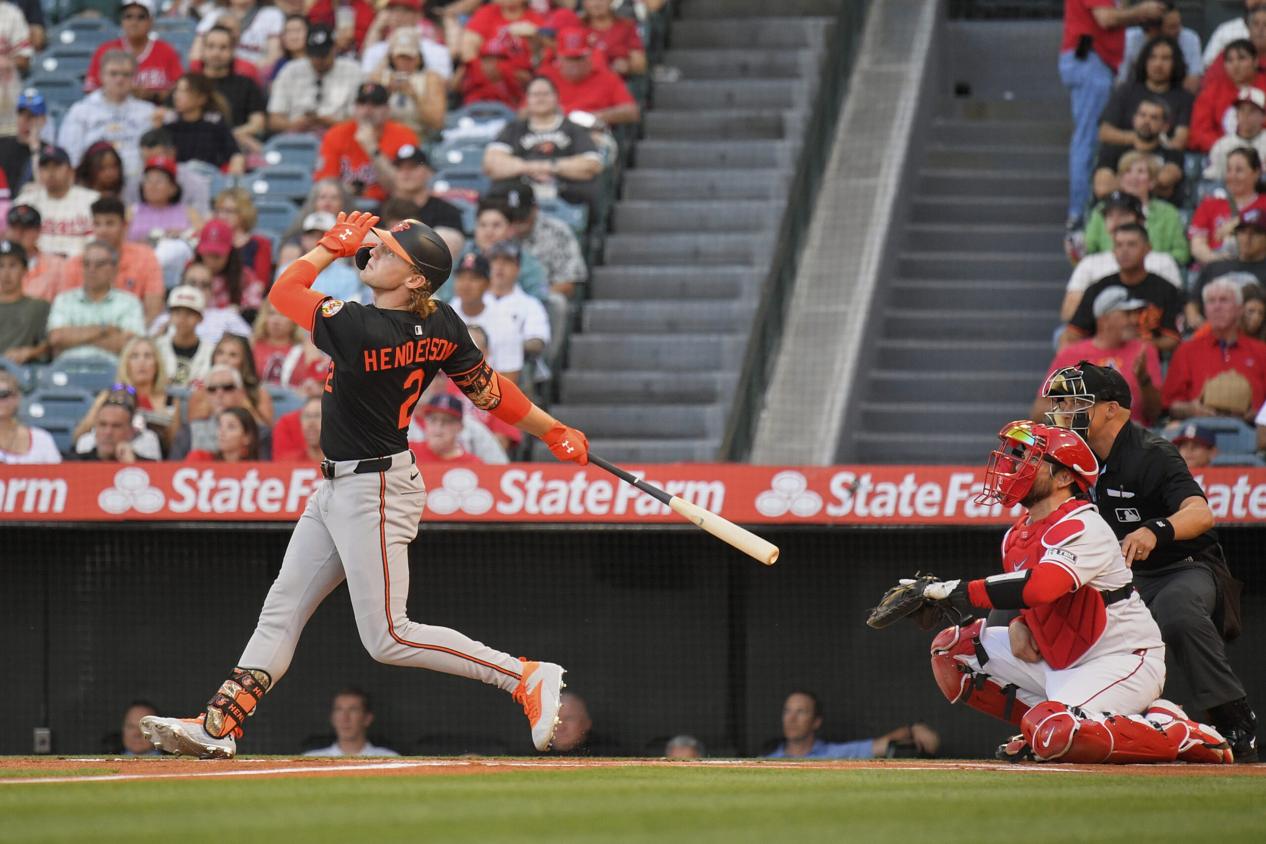 Baltimore Orioles' Gunnar Henderson, left, hits a solo home run...
