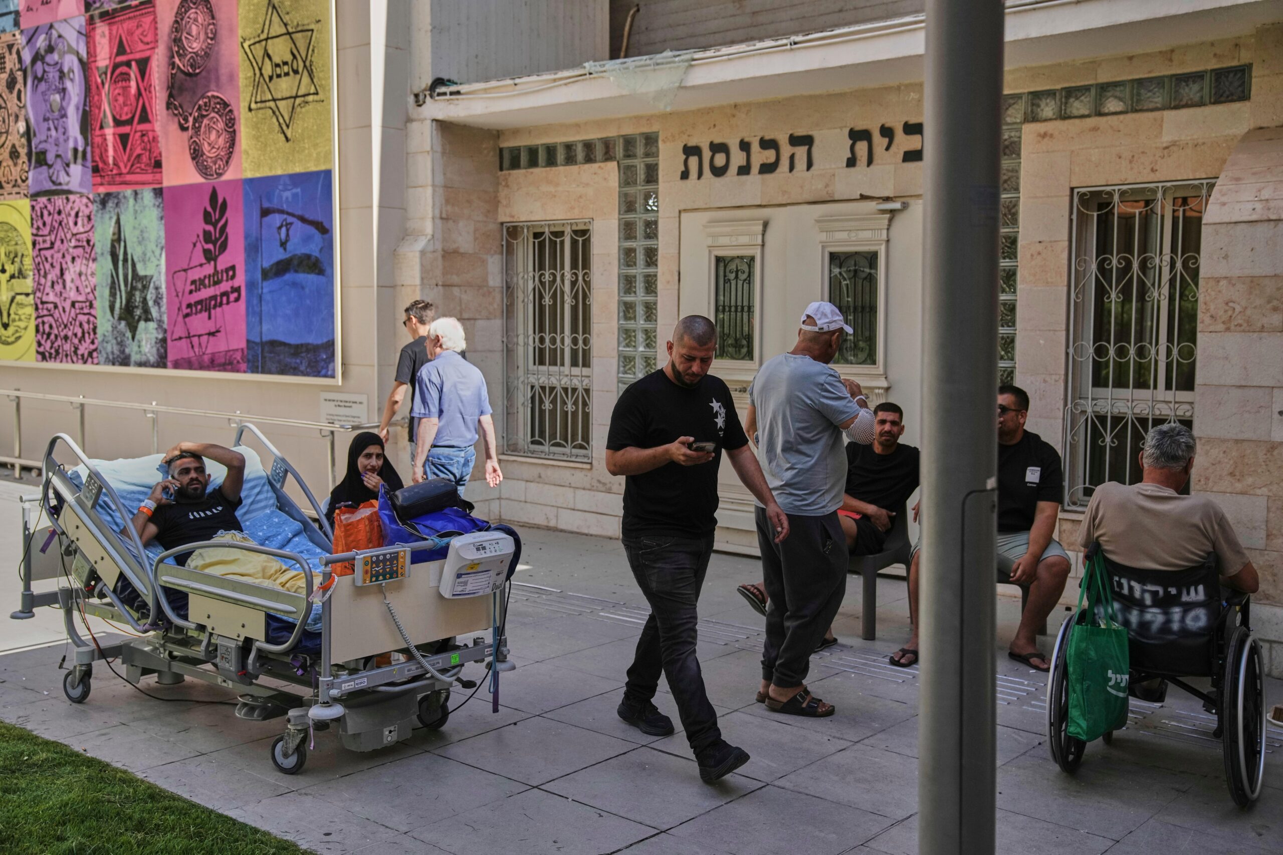 Patients rest outdoors after a building of the Soroka hospital...