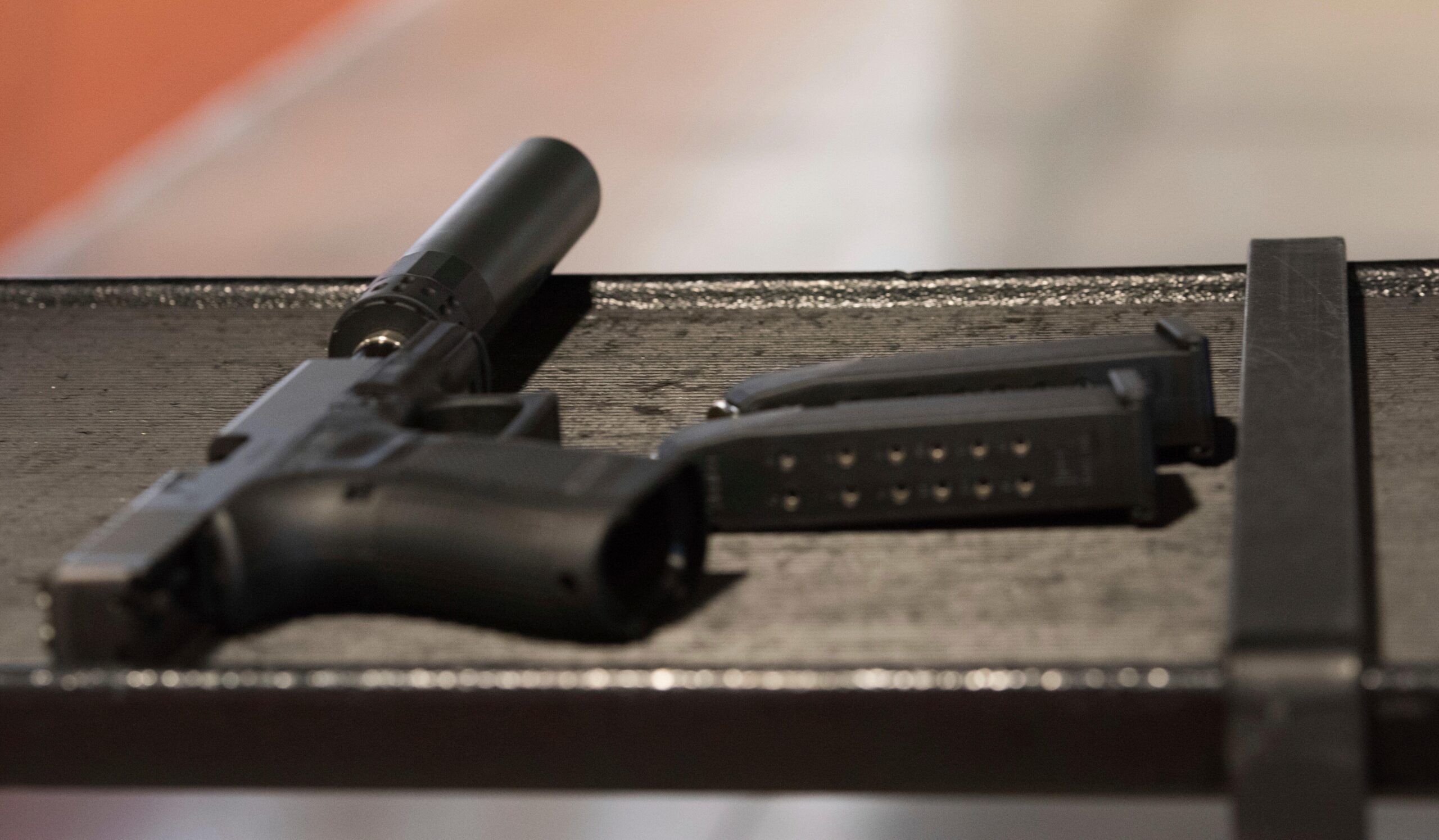 FILE – A handgun with a silencer and two magazines...