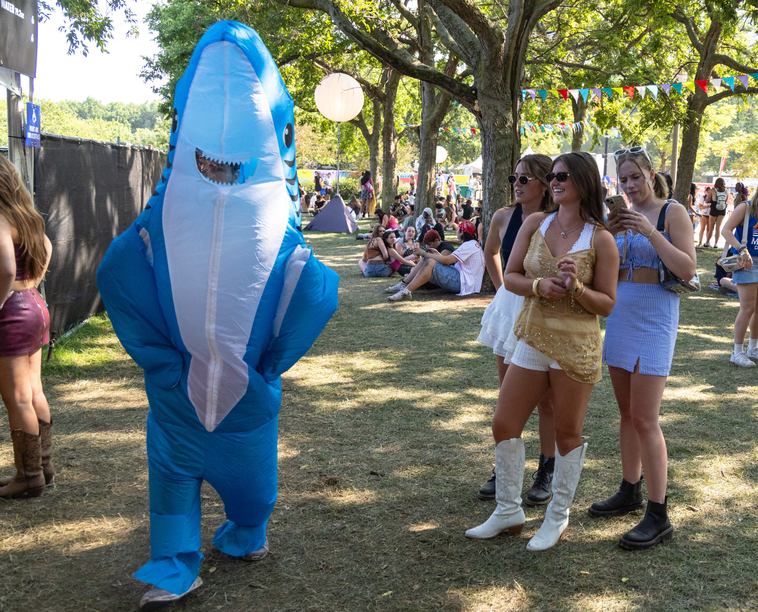 A shark mascot dances in front of a crowd during...