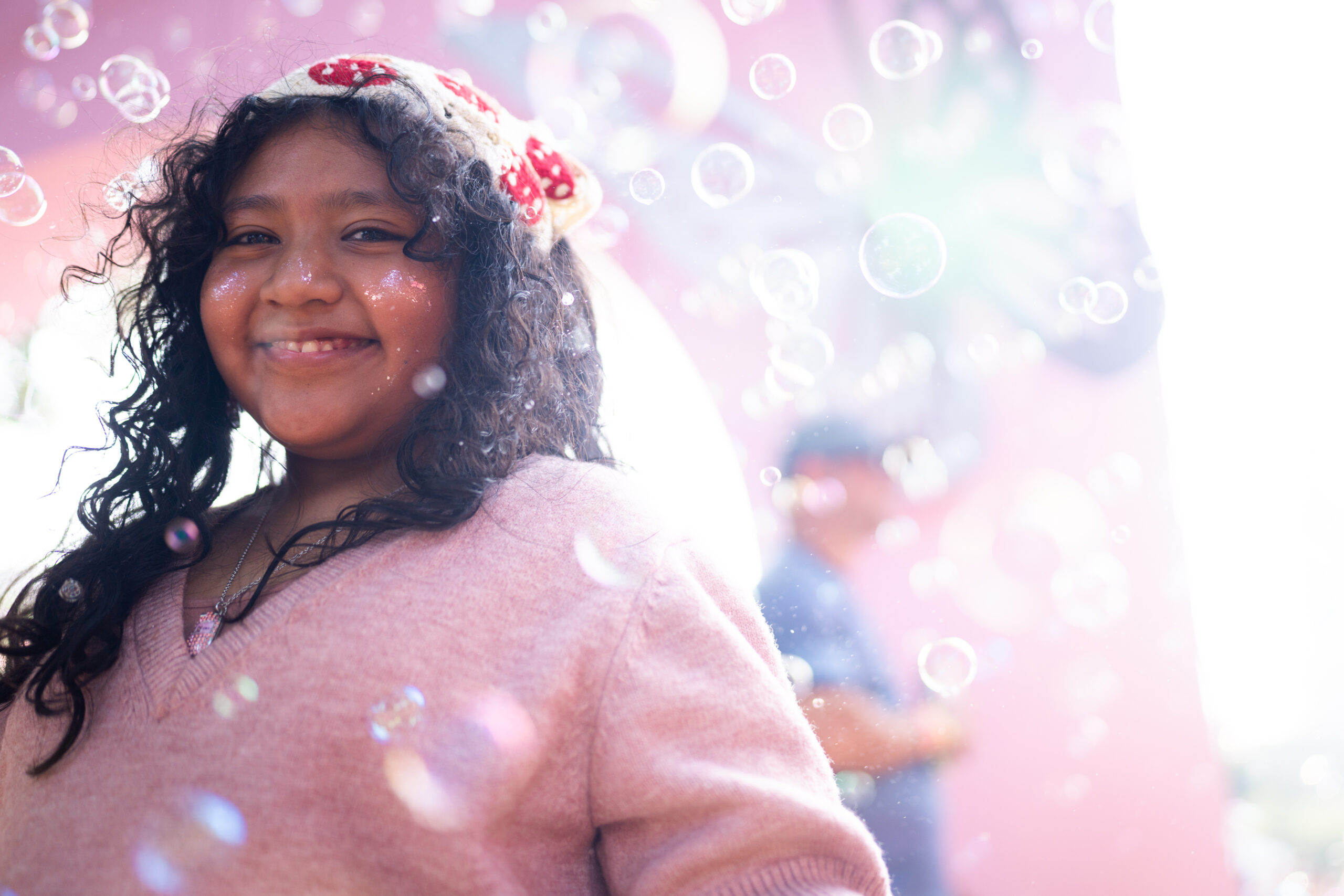 Victoria Gonzalez, 8, of St. Louis, Mo., smiles among bubbles...
