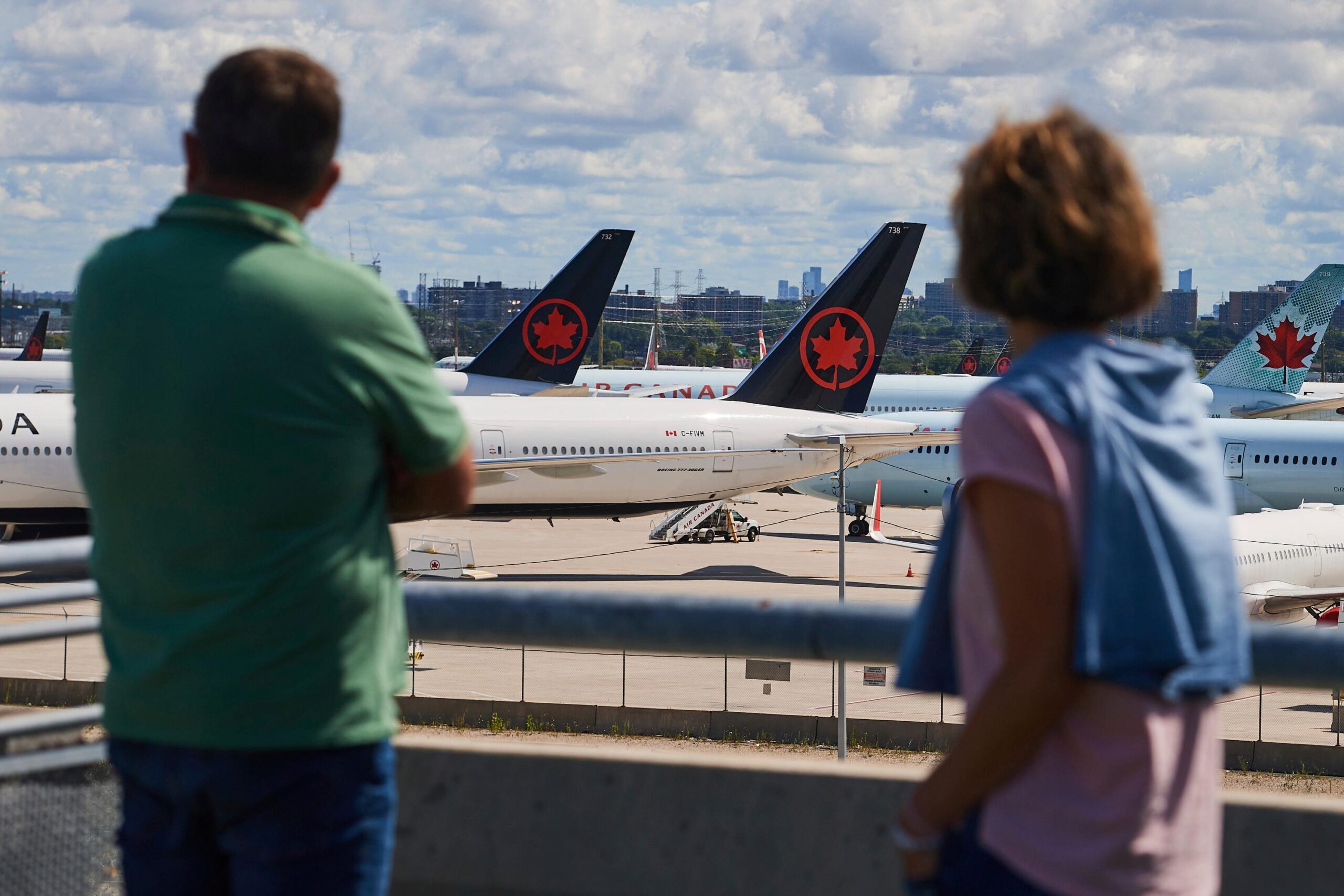 Travelers look out over grounded Air Canada planes as flight...