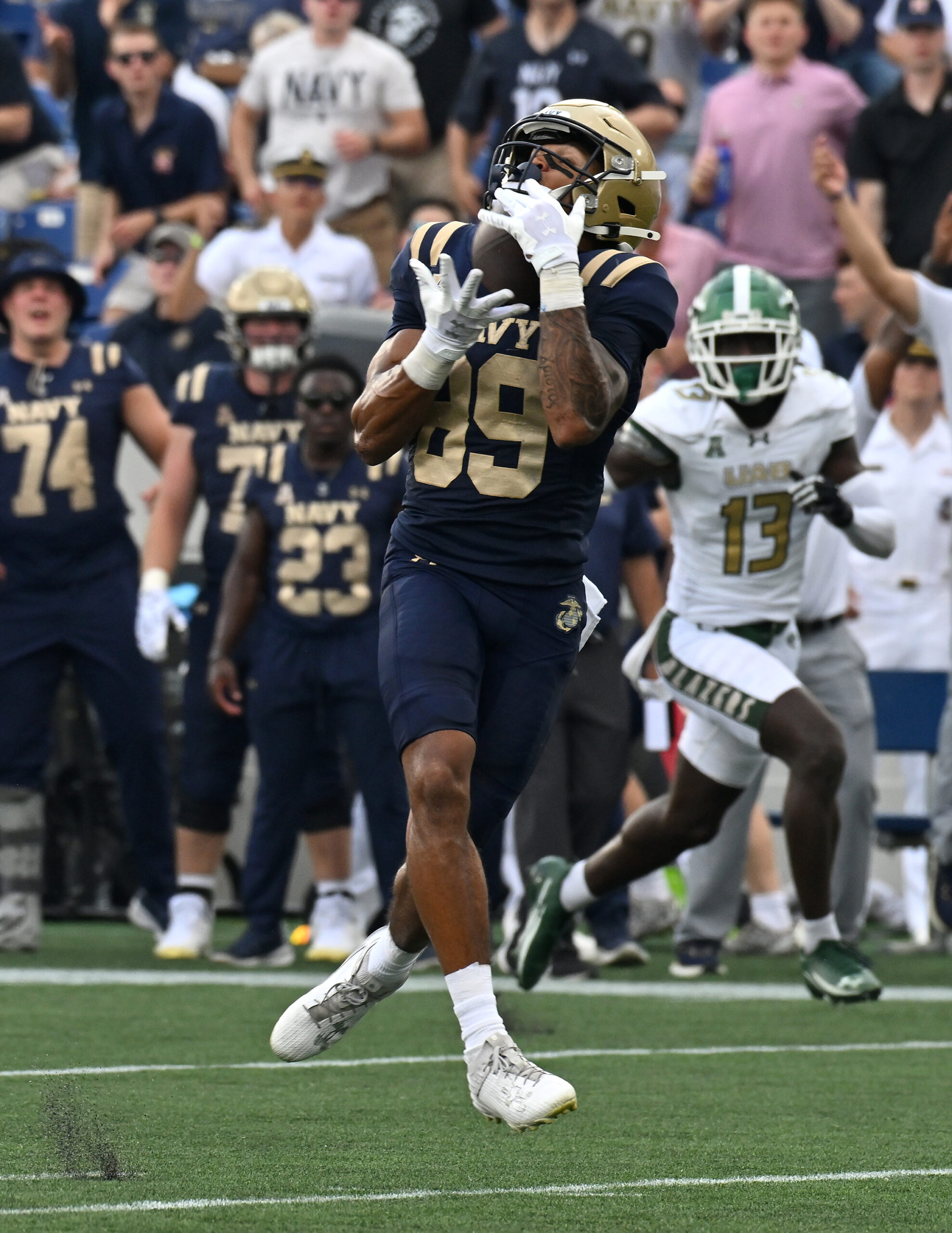 Navy’s Luke Hutchison catches a pass from Blake Horvath and...