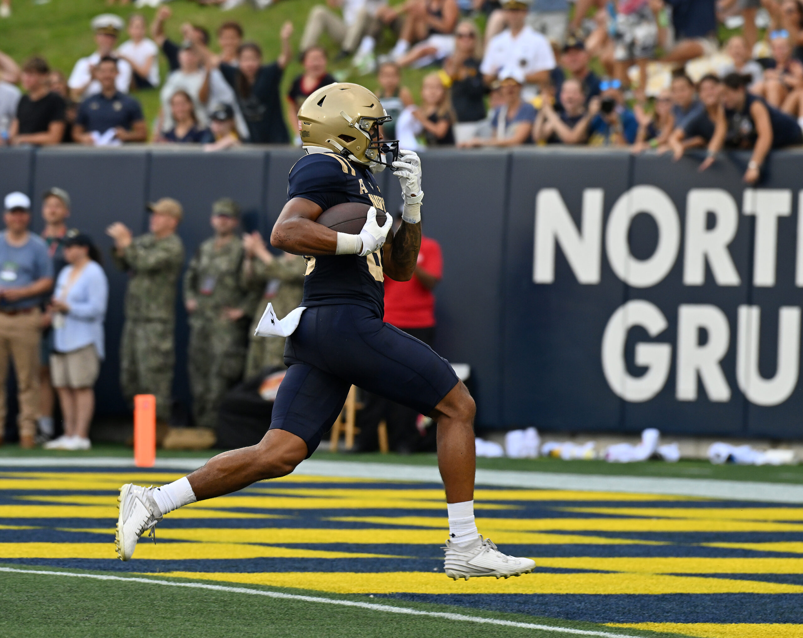 Navy’s Luke Hutchison catches a pass from Blake Horvath and...
