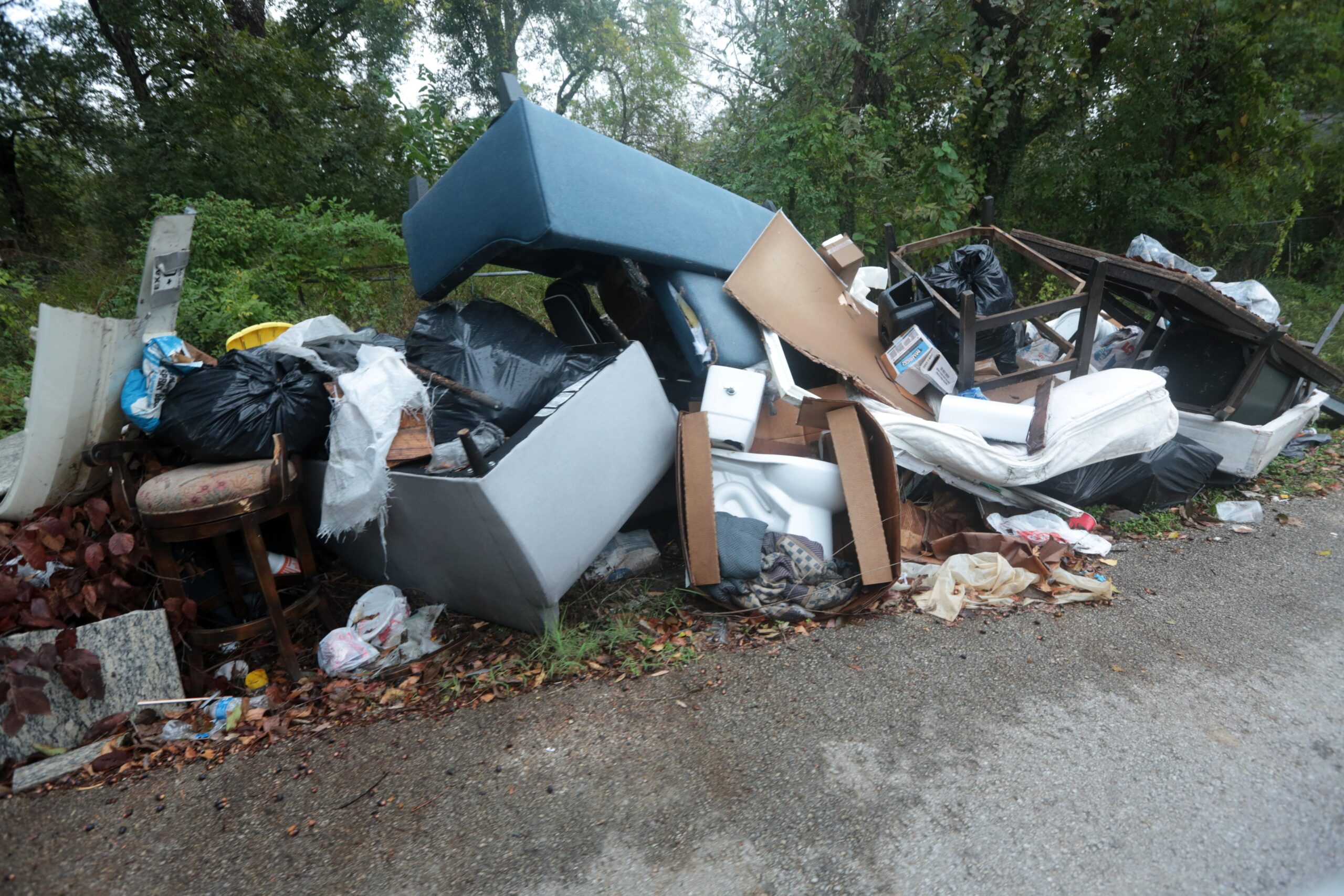 A toilet lays among large piles of trash and debris...