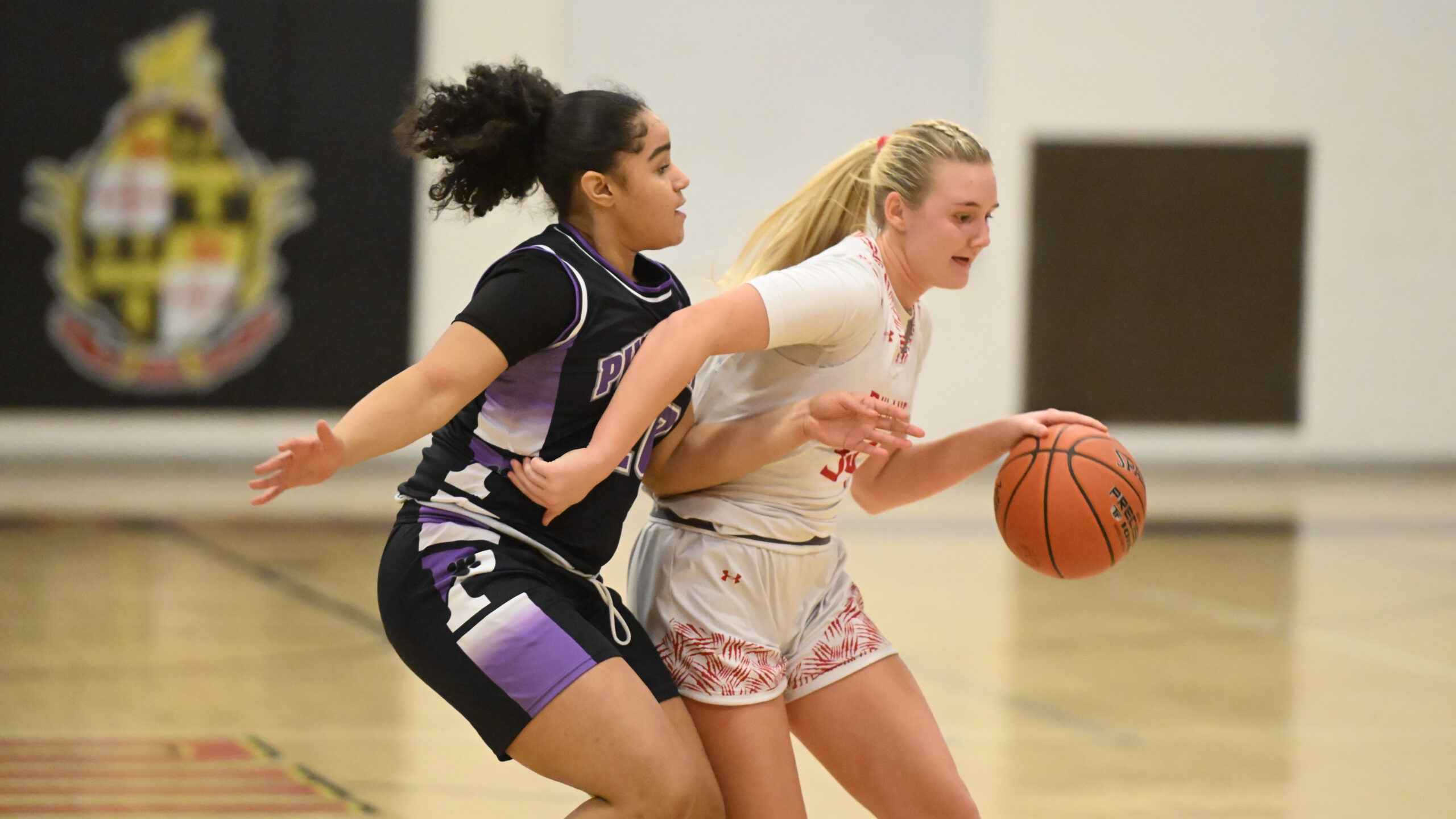 Dulaney's Torunn Spencer tries to dribble away from pressure by...