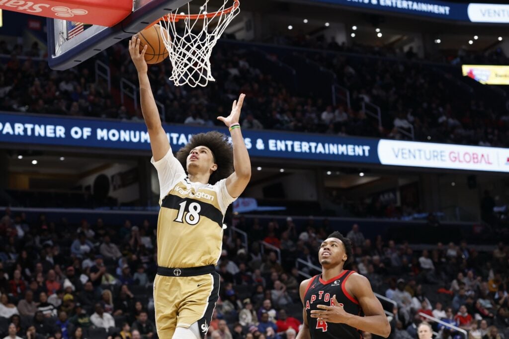 Washington Wizards forward Kyshawn George (18) shoots the ball as Toronto Raptors forward Scottie Barnes (4) looks on in the second half at Capital One Arena.